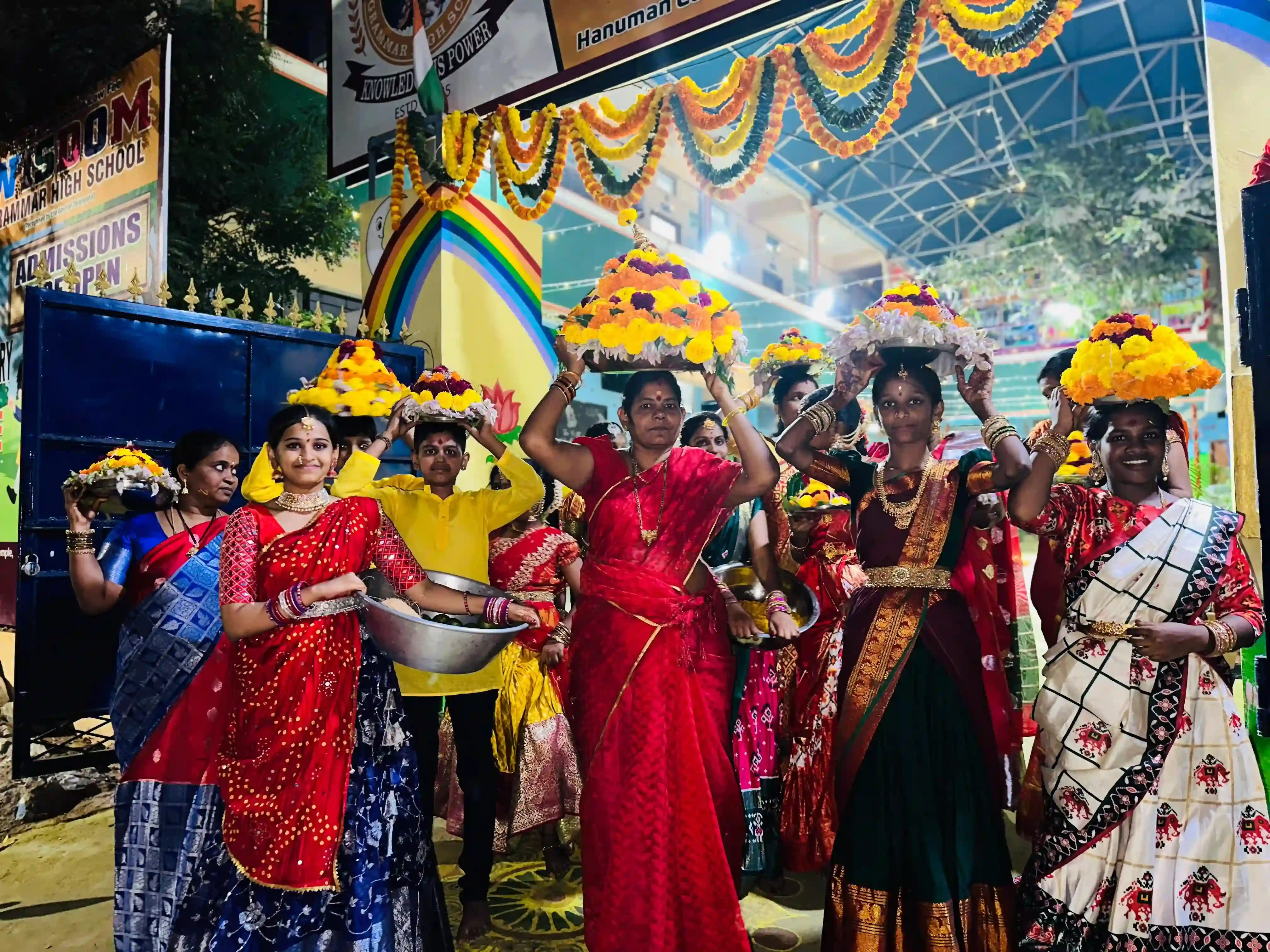 Students participating in Bathukamma festival with flower arrangements
